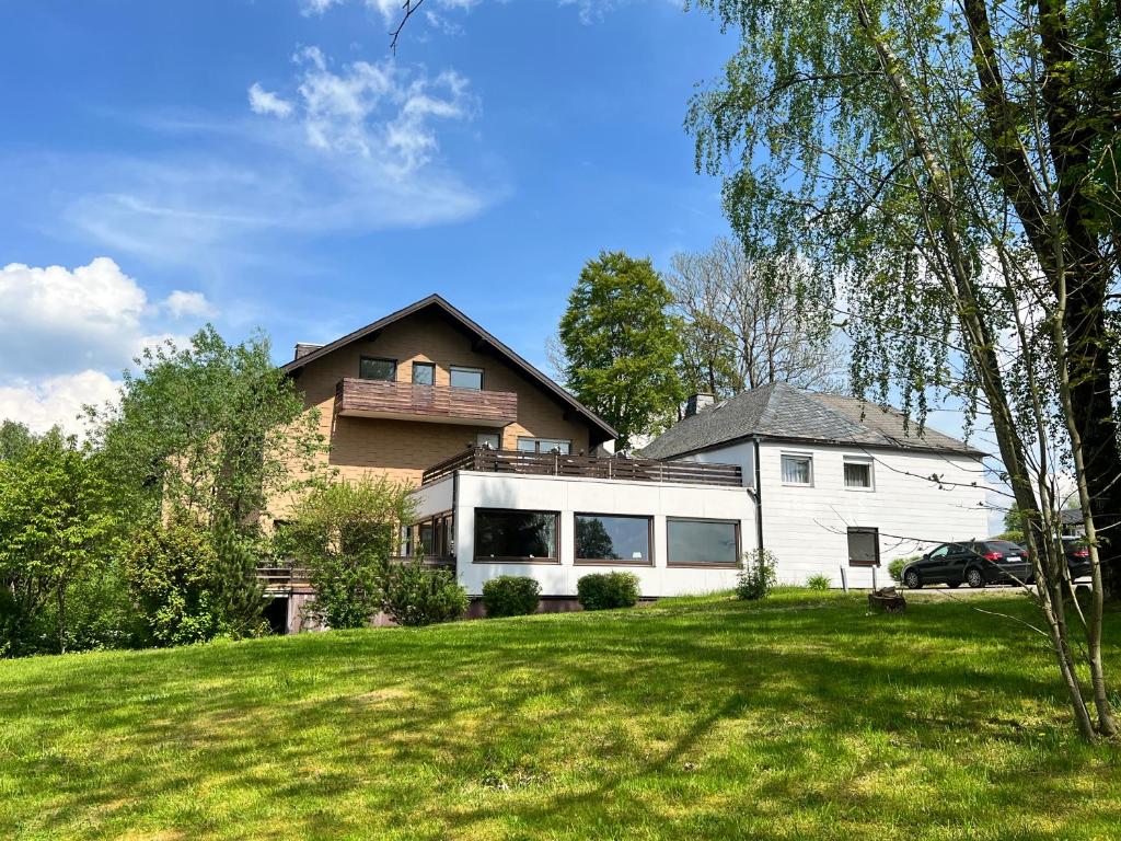 a house on a hill with a green yard at Unsereins Hotel in Bad Steben