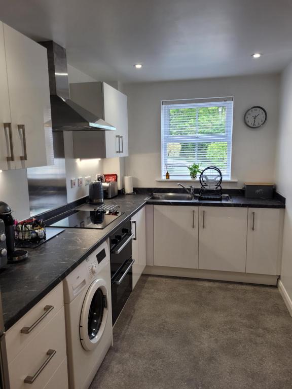 a kitchen with a sink and a stove top oven at 1 Merchants Gate - 2 bedroom, city apartment with private parking in York