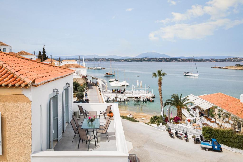 a balcony of a house with a view of the water at Old Port Spetses Mansion in Spetses
