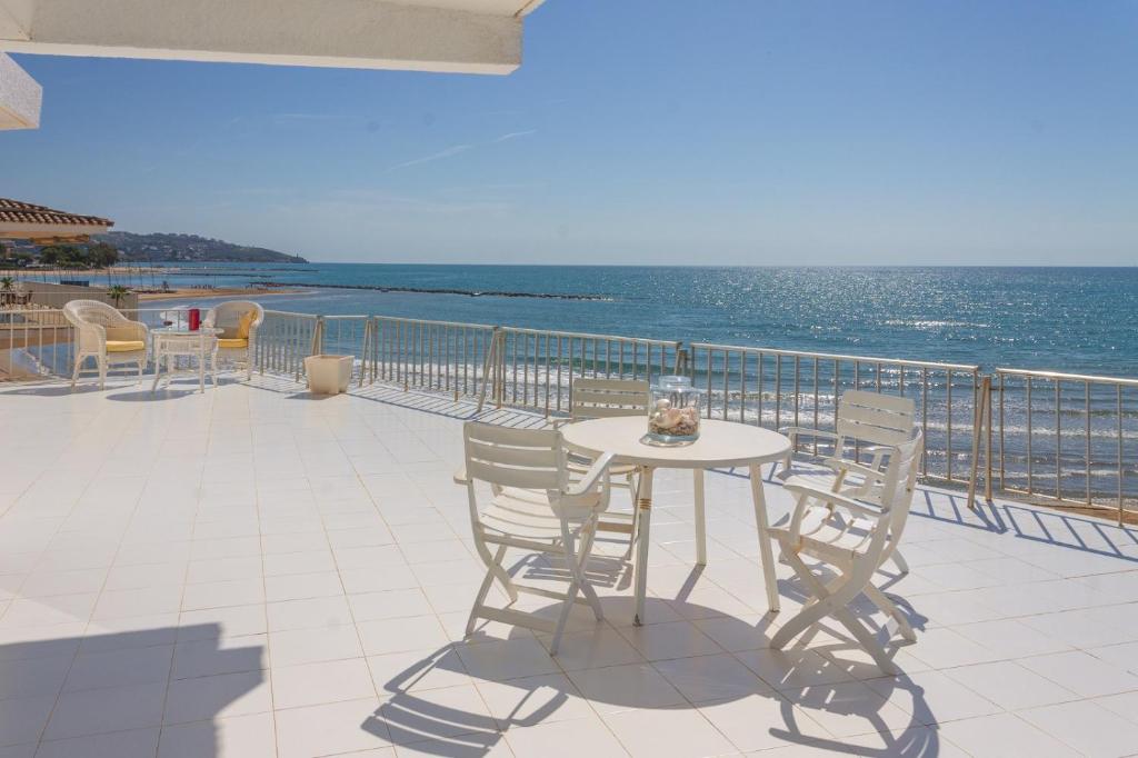 a table and chairs on a balcony overlooking the ocean at Magnifica VILLA AIREOLA frente al mar in Benicàssim