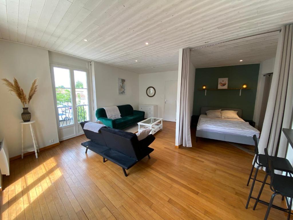 a bedroom with a bed and a couch and a chair at Le logis des Halles in Cerizay