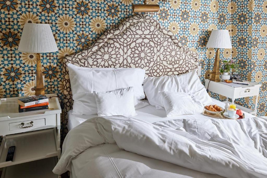 a bedroom with a bed with white sheets and pillows at Château Gütsch in Luzern