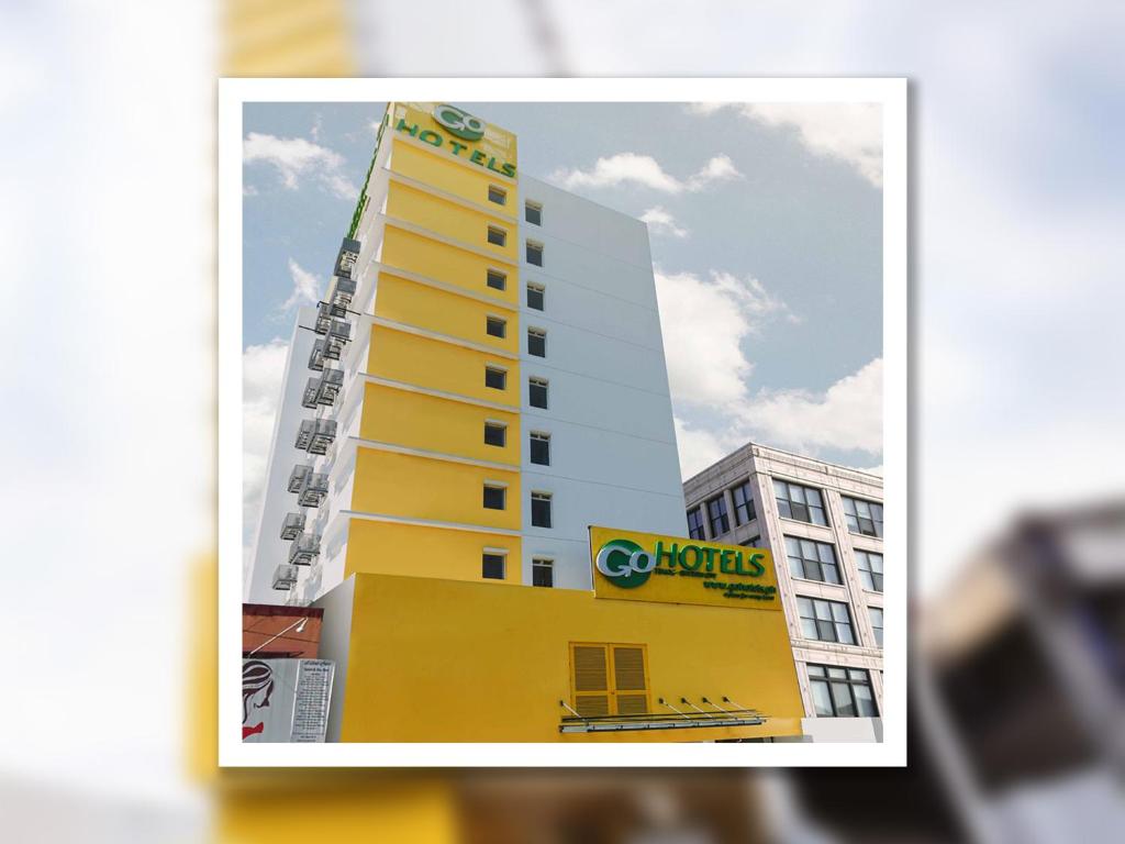 Go Hotels Timog في مانيلا: مبنى أصفر طويل مع علامة كوبرز عليه