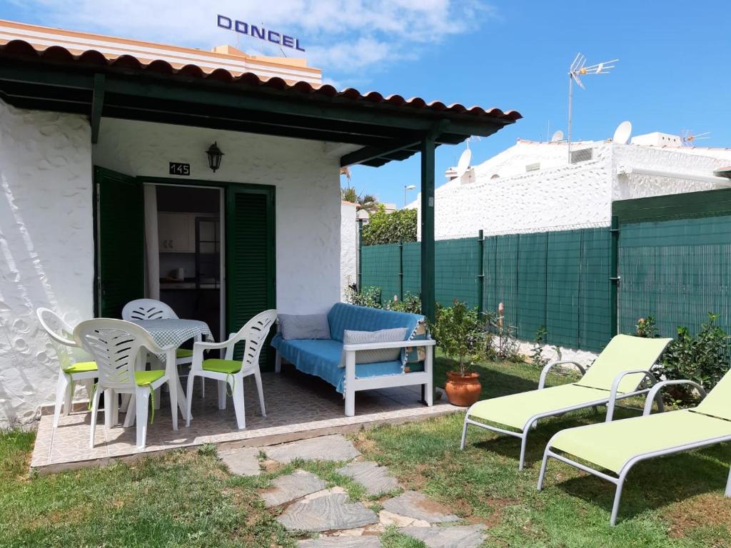 a patio with chairs and a table and a couch at bungalow with private garden in Playa del Ingles