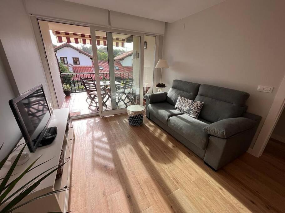 a living room with a couch and a television at Los Girasoles in Comillas