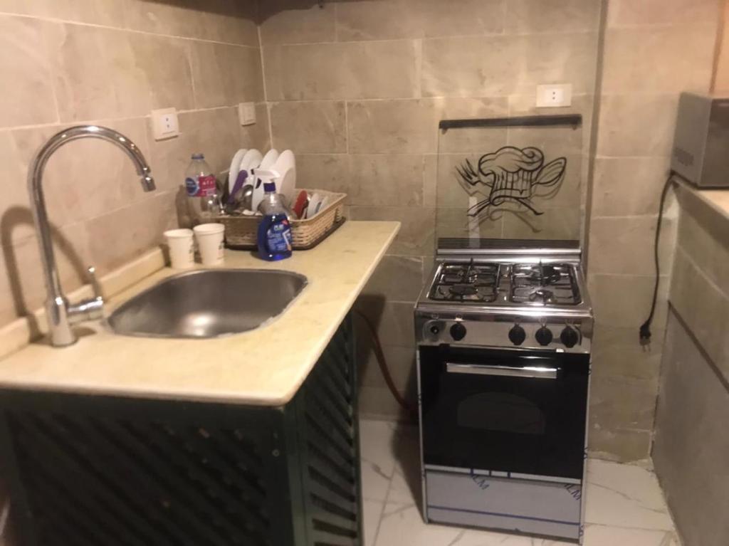 a kitchen with a sink and a stove at The studio has a private entrance for visitors in Cairo