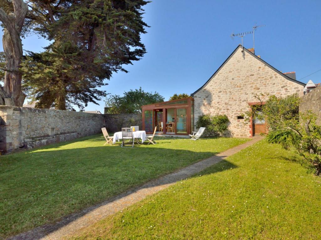 a stone cottage with a table and chairs in a yard at Holiday Home Moulin Bastard by Interhome in Le Croisic