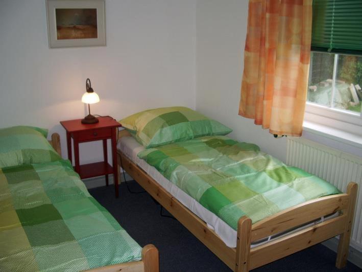 ein Schlafzimmer mit 2 Betten und einem Tisch mit einer Lampe in der Unterkunft Ferienhaus Strobel in Bardowick