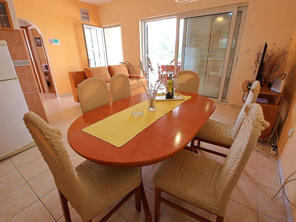 drewniany stół jadalny z krzesłami i kuchnia w obiekcie Holiday Home Anderson by Interhome w mieście Prigradica