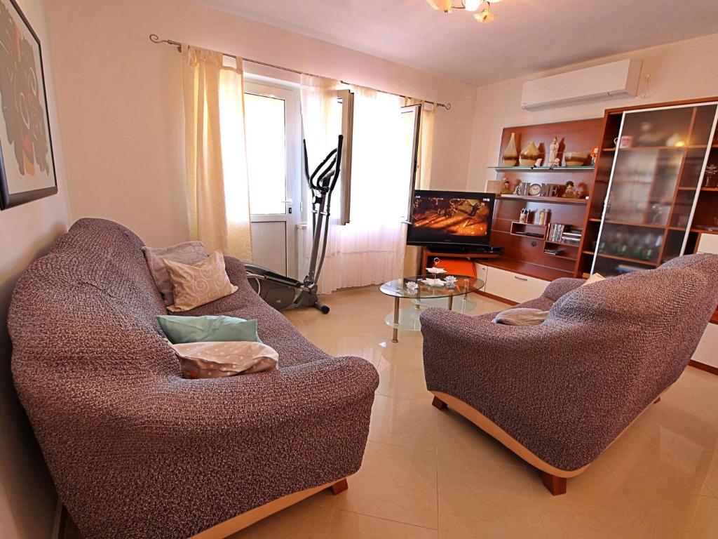 salon z dwoma krzesłami i telewizorem w obiekcie Holiday Home Damjanović by Interhome w mieście Prigradica