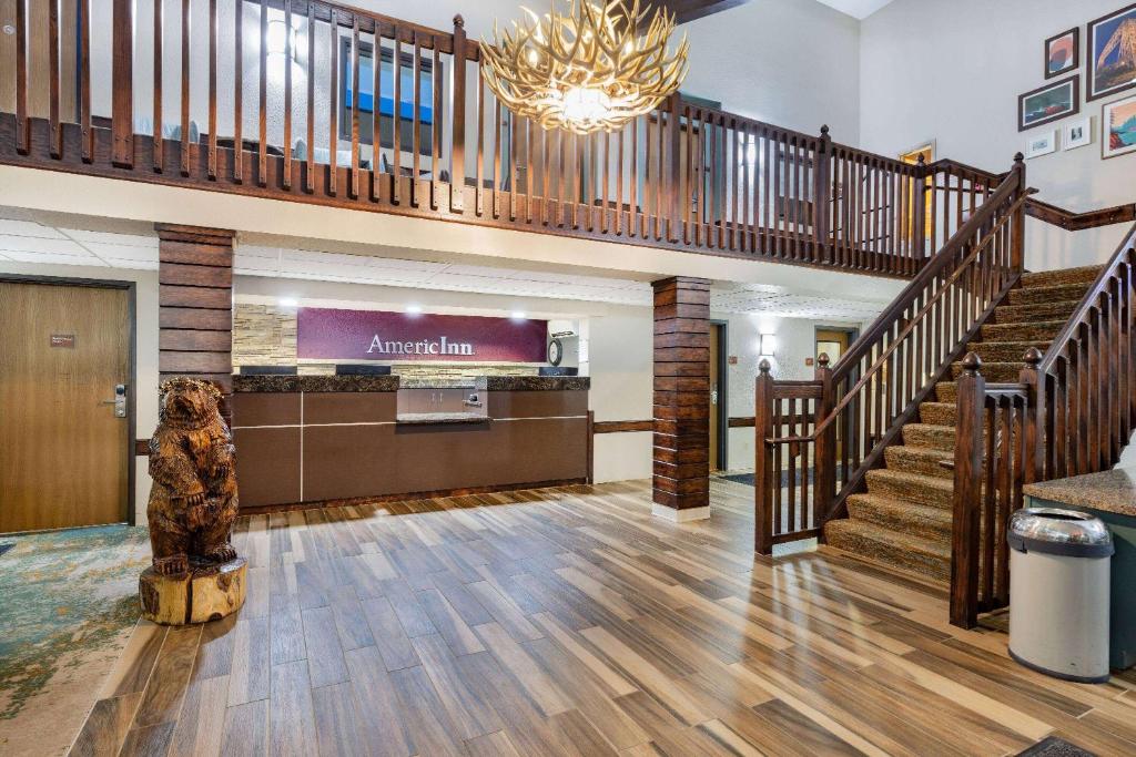 a lobby with a staircase and a large lobby with a museum at AmericInn by Wyndham Duluth South Proctor Black Woods Event Ctr in Duluth