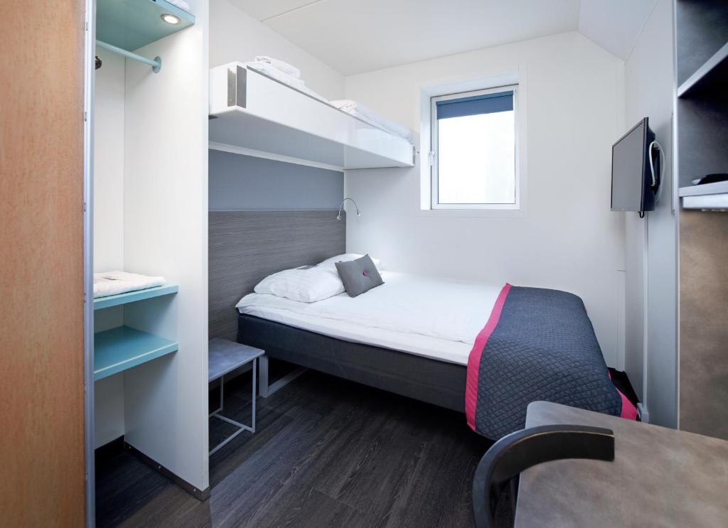 a small room with a bed and a window at Cabinn Metro in Copenhagen
