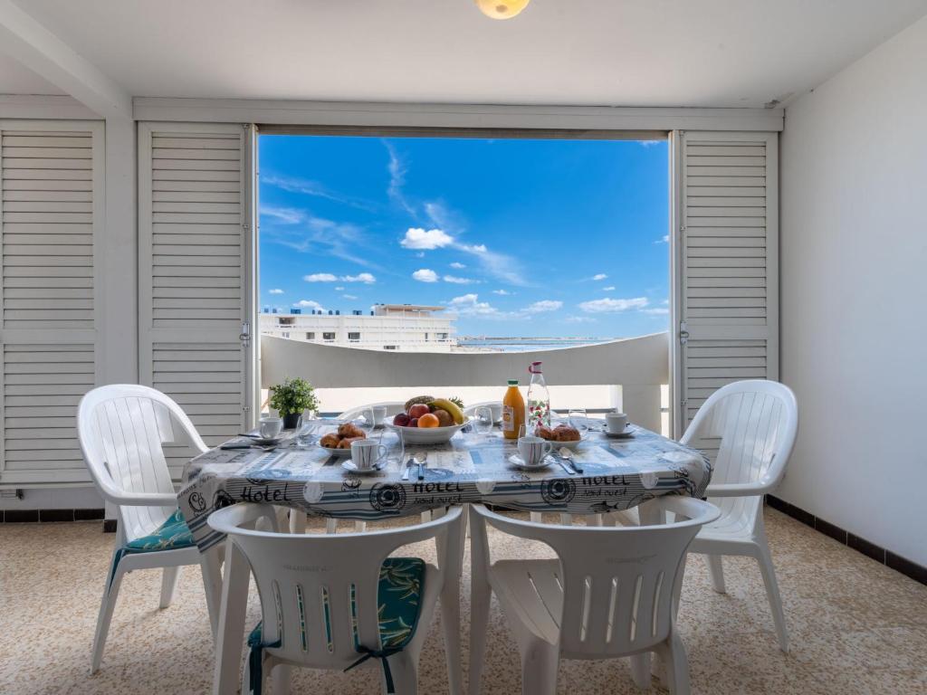 a dining room with a table with a view of a cruise ship at Apartment La Résidence de la Mer by Interhome in Le Grau-du-Roi