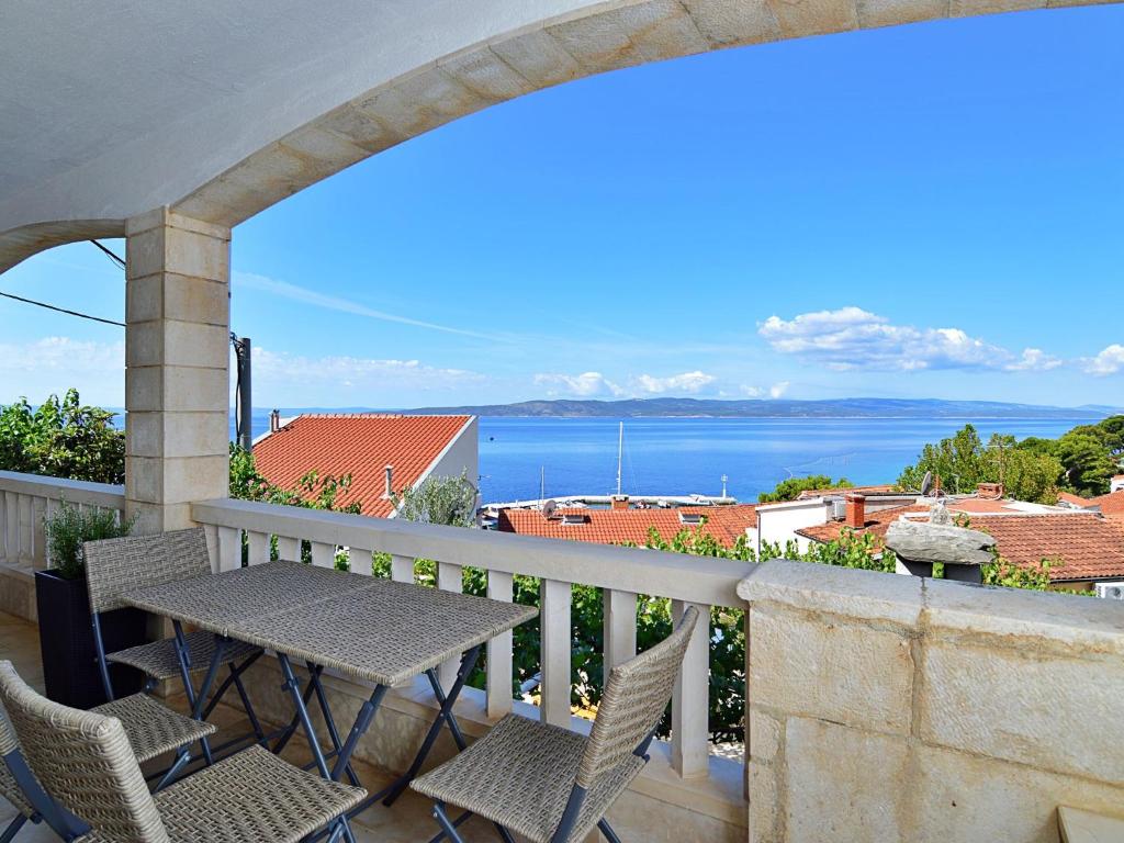 a balcony with a table and chairs and a view of the ocean at Holiday Home Ivo - MKA230 by Interhome in Brela