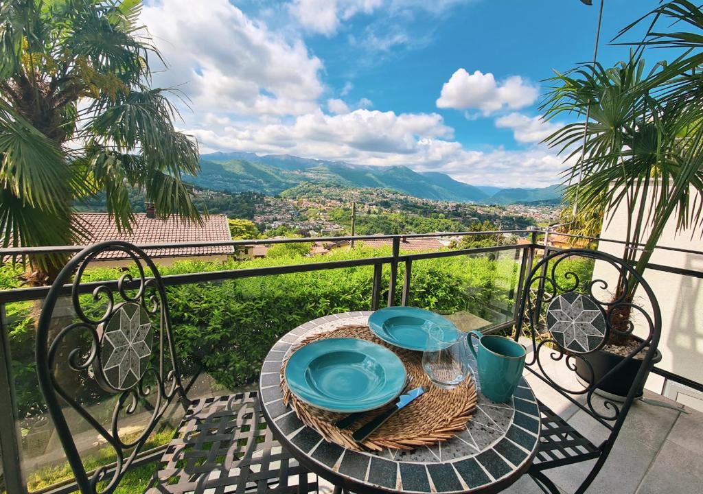 una mesa con placas azules en el balcón en Suite Apartment with a view and free parking, en Lugano