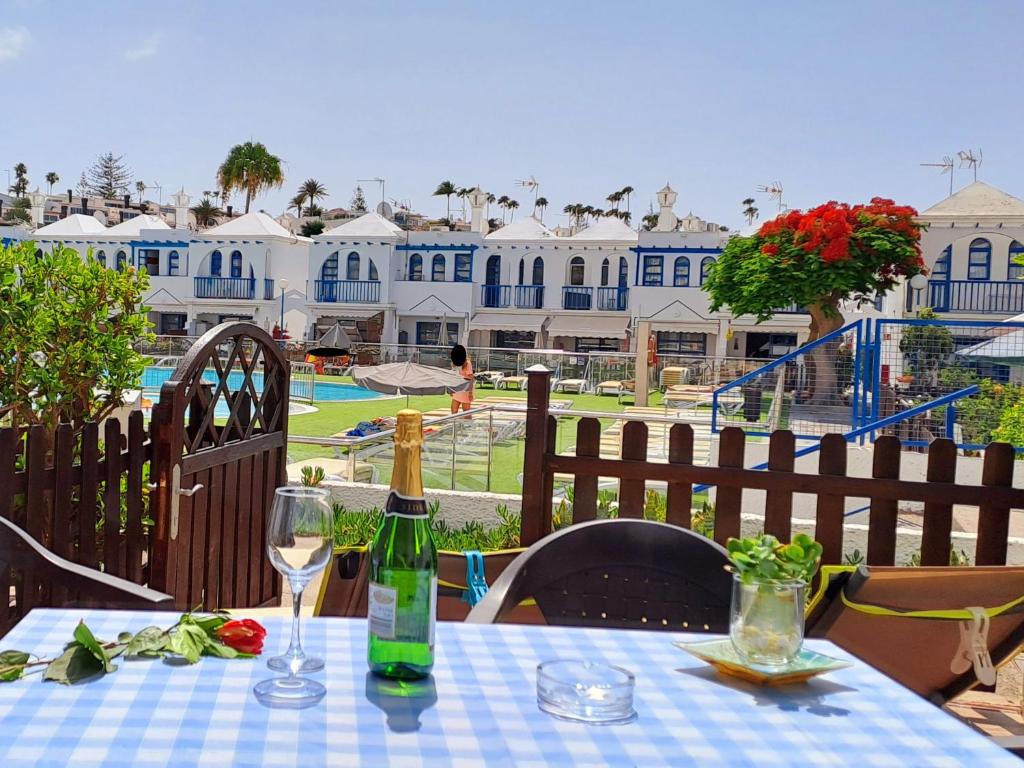 einen Tisch mit einer Flasche Wein und zwei Gläsern in der Unterkunft BungaLove Maspalomas in Maspalomas