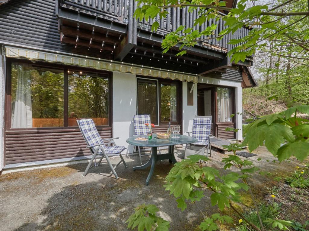 un patio con mesa y sillas frente a una casa en Holiday Home Am Sternberg 16 by Interhome, en Frankenau