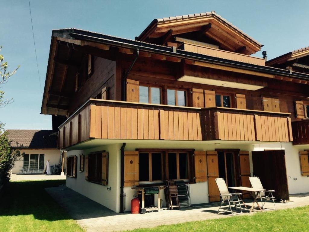 een groot houten huis met stoelen ervoor bij Apartment Alpine Retreat by Interhome in Adelboden