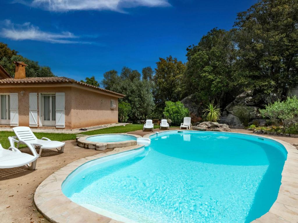 une piscine avec des chaises et une maison dans l'établissement Villa Corba Bala by Interhome, à Porto-Vecchio