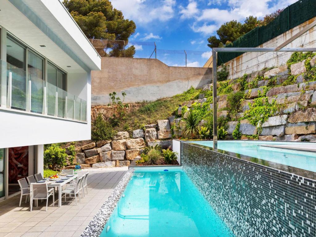 a house with a swimming pool next to a building at Holiday Home Nathalie by Interhome in Sant Antoni de Calonge