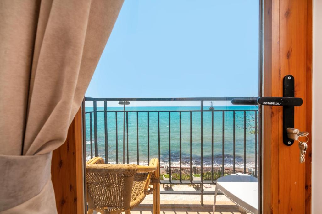 a room with a balcony with a view of the ocean at Beach House Hotel in Side