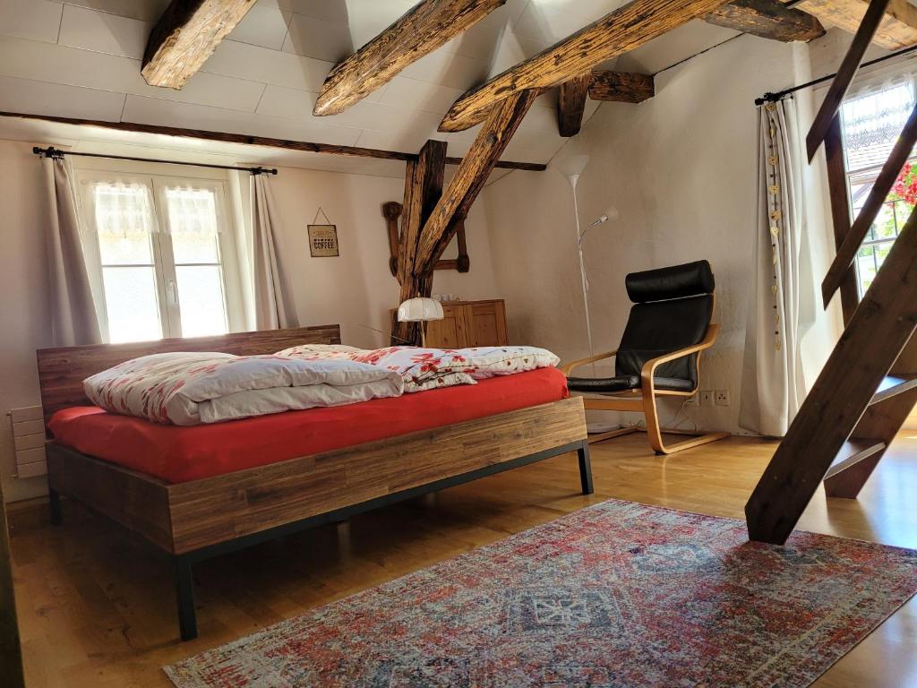 ein Schlafzimmer mit einem Bett und einem Stuhl darin in der Unterkunft Ferienhaus Altstadt CH-Rheinfelden in Rheinfelden