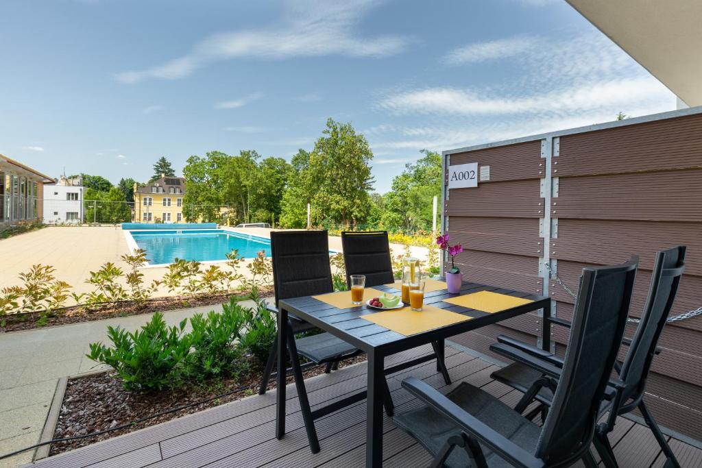 a patio with a table and chairs and a pool at Pauzo Balaton in Balatonföldvár