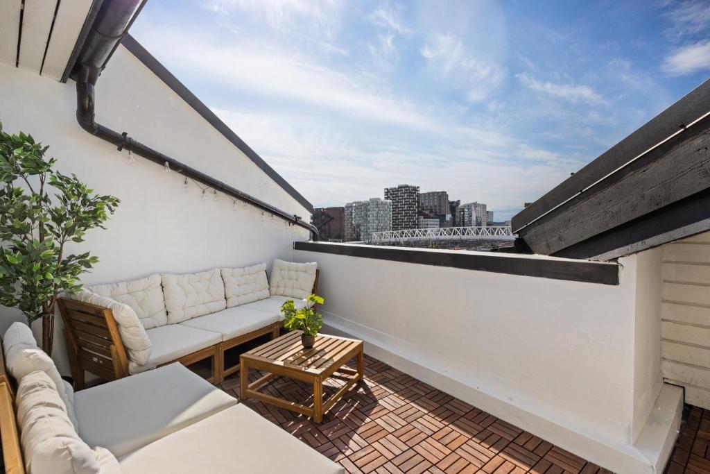オスロにあるUrban Panorama - New, Central & Private Terraceのソファとテーブル付きのバルコニー