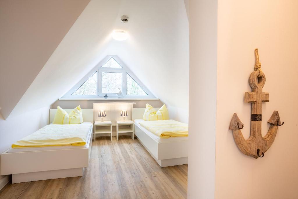 een slaapkamer op zolder met 2 bedden en een anker aan de muur bij Alte Liebe Zinnowitz in Zinnowitz