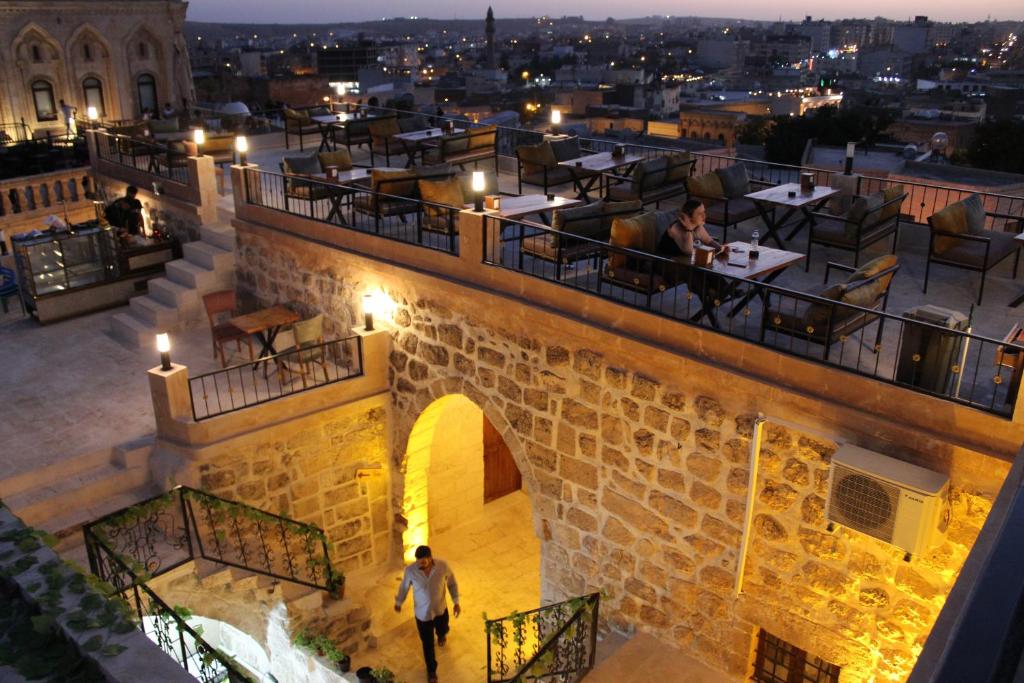 Un homme descend les escaliers d'un restaurant la nuit dans l'établissement Mons Masius Boutique Hotel Cafe, à Midyat
