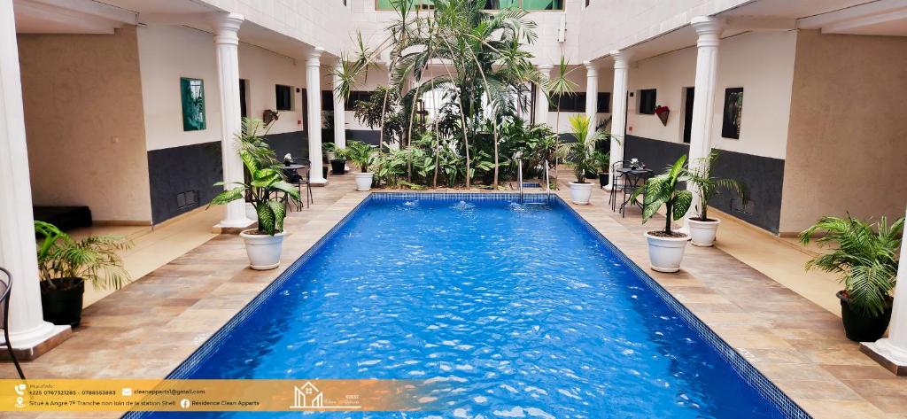 a swimming pool in a building with potted plants at Residence Clean Apparts in Abidjan