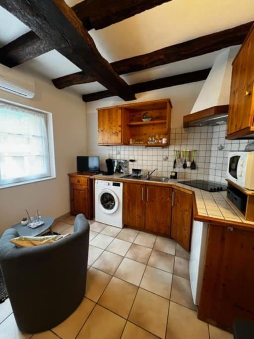 a kitchen with a couch and a stove top oven at #Le Rue des 2 Porches #F2 avec Cours #HyperCentre in Brive-la-Gaillarde