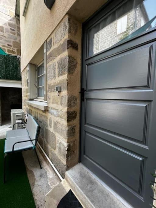 a garage door with a bench next to a building at #Le Rue des 2 Porches #F2 avec Cours #HyperCentre in Brive-la-Gaillarde