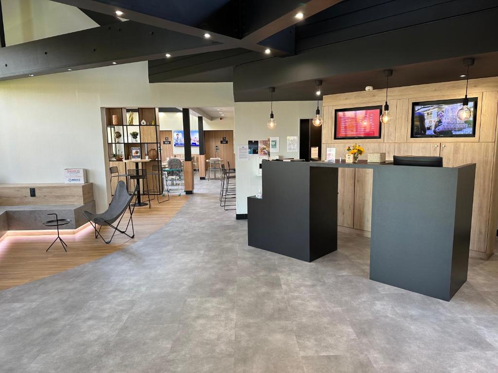 a lobby with a counter and tables in a room at ibis Saint-Lô in Saint Lo