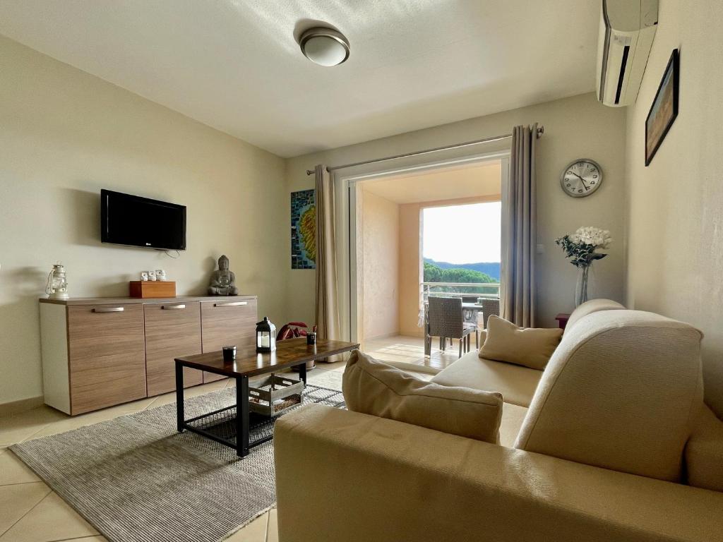 uma sala de estar com um sofá e uma mesa em Appartement Résidence Salin Bay em Porto-Vecchio