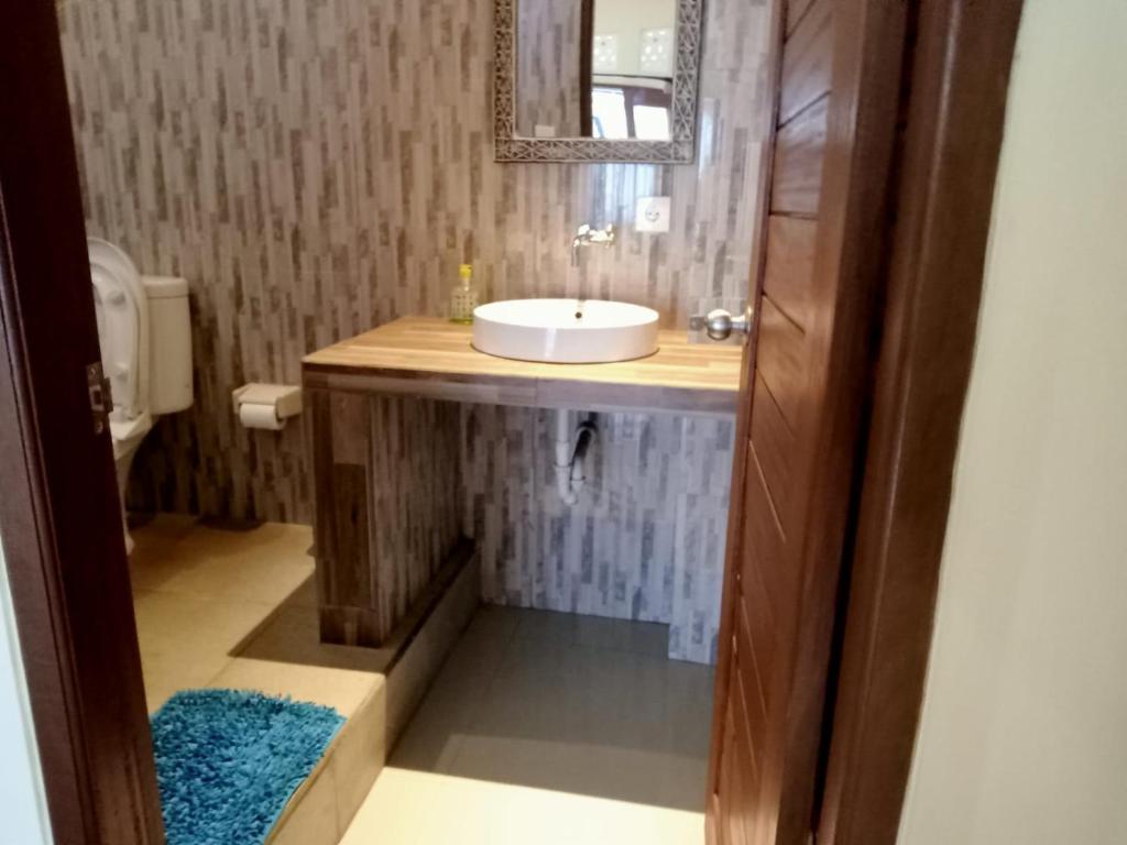 une salle de bain avec un lavabo et un miroir dans l'établissement Yudis Guest House, à Ubud