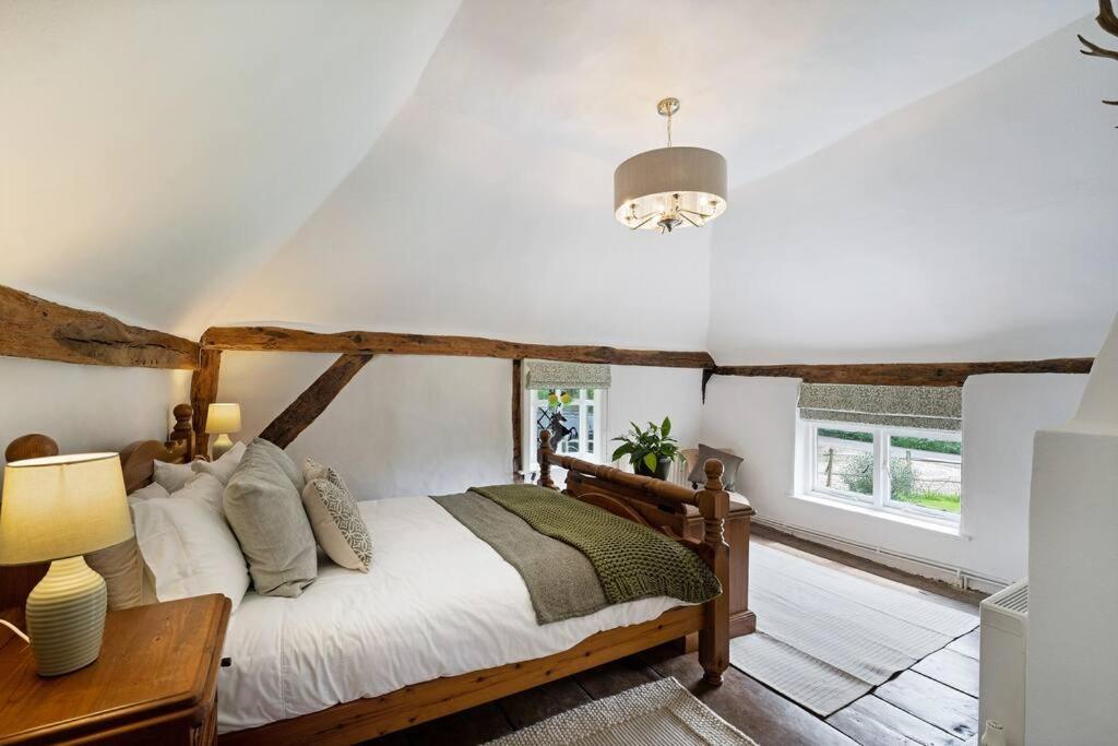 um quarto com uma cama, uma mesa e um candeeiro em Charming, dog friendly cottage em Doddington