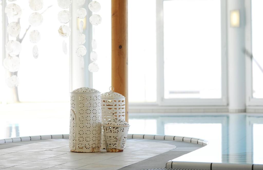 three white vases sitting on top of a table at Seewirt & Haus Attila in Podersdorf am See