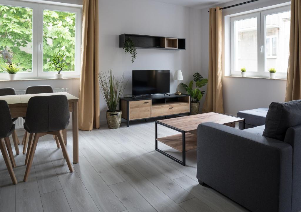 sala de estar con sofá, mesa y TV en Apartament Wiosenny Kamienica Grochów with free parking, en Varsovia