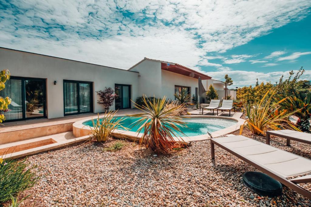 a backyard with a swimming pool and a house at Villa luxe Oasis de Satteva in L&#39;Isle-sur-la-Sorgue