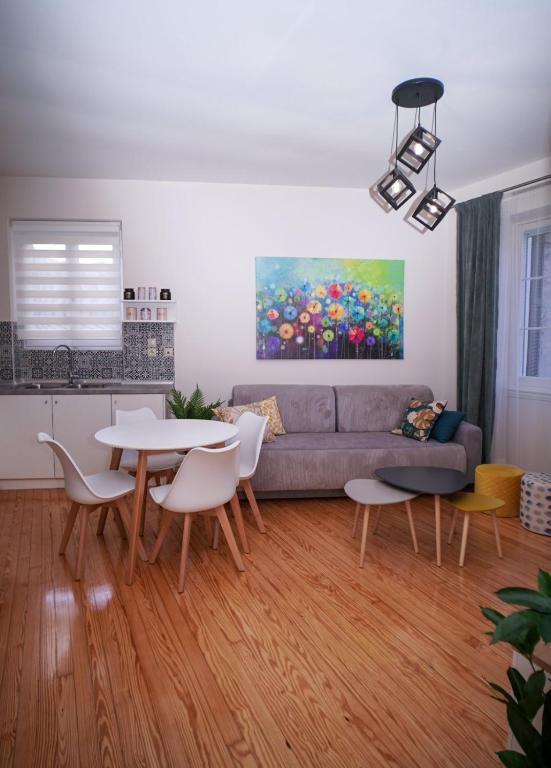 Una sala de estar con un sofá, una mesa y sillas. en Casa nella Fortezza, Corfu Old Town, en Corfú