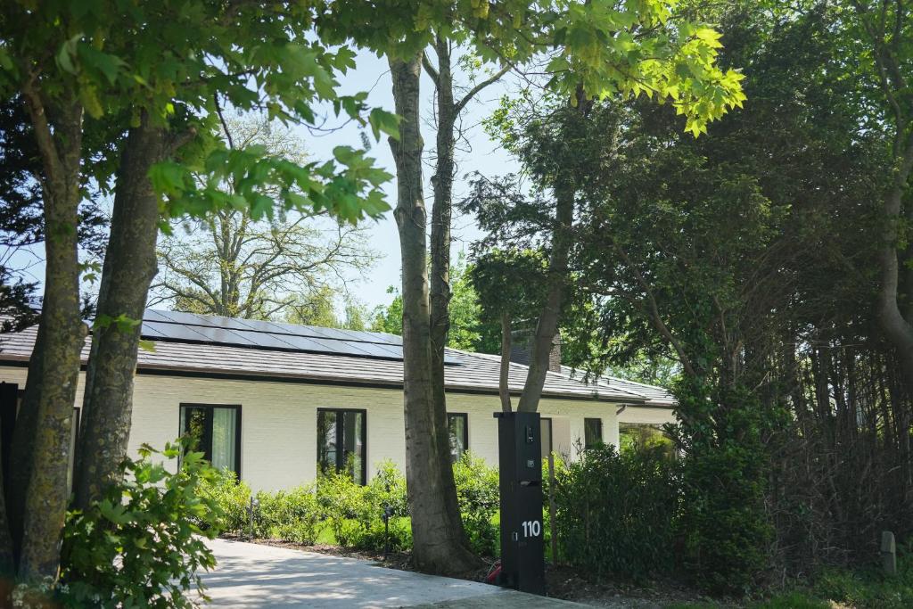 ein weißes Haus mit Bäumen davor in der Unterkunft Gasthuis Veurne in Veurne