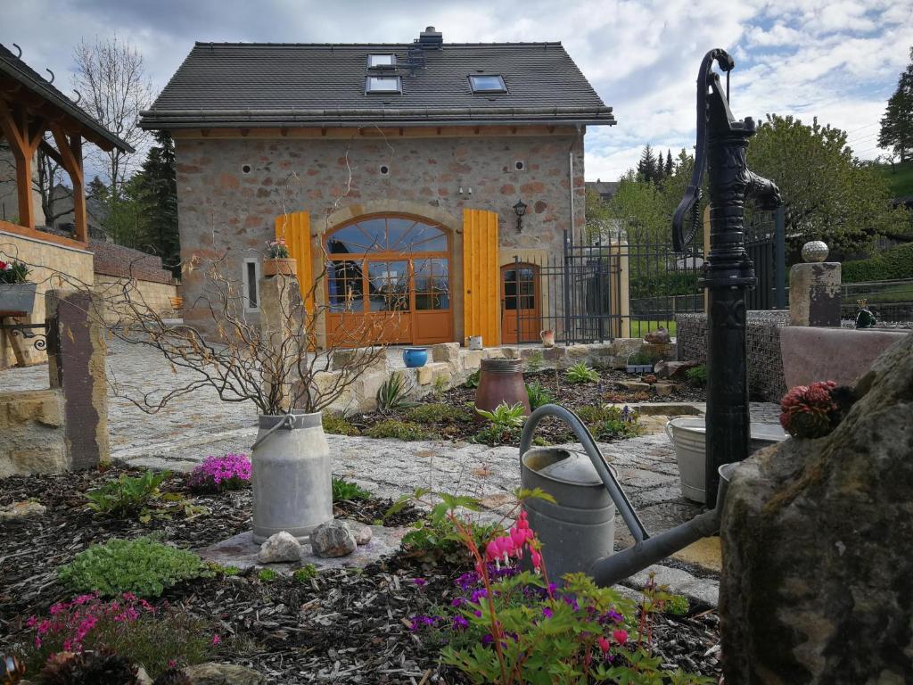 a house with a garden with flowers in front of it at Ferien in der alten Scheune in Kurort Altenberg