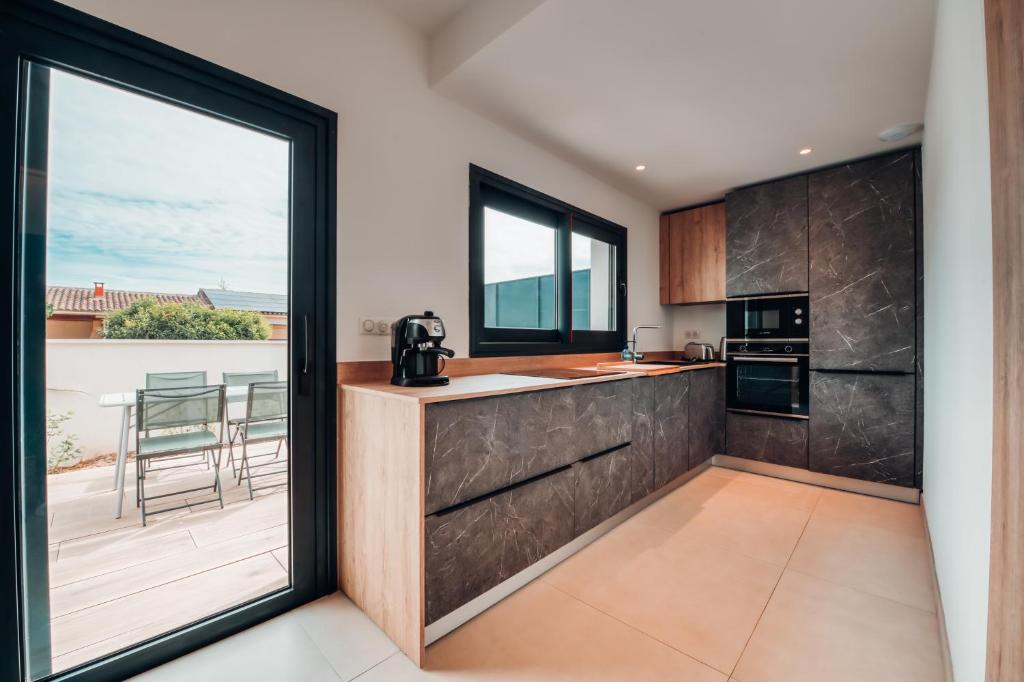 a kitchen with a large glass door leading to a patio at Villa luxe Oasis de Satteva in L&#39;Isle-sur-la-Sorgue