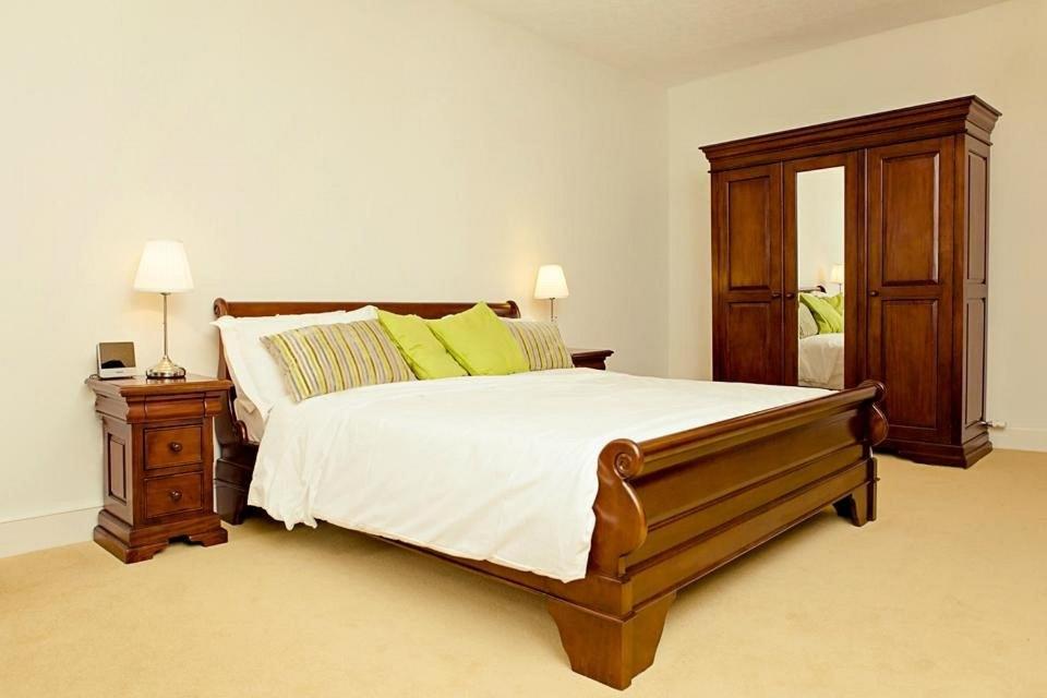 1 dormitorio con 1 cama y vestidor con espejo en Kings Arms Hotel, en Bicester