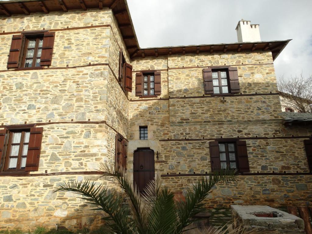 an old stone building with windows and a door at Iliopetra Suites in Agios Lavrentios