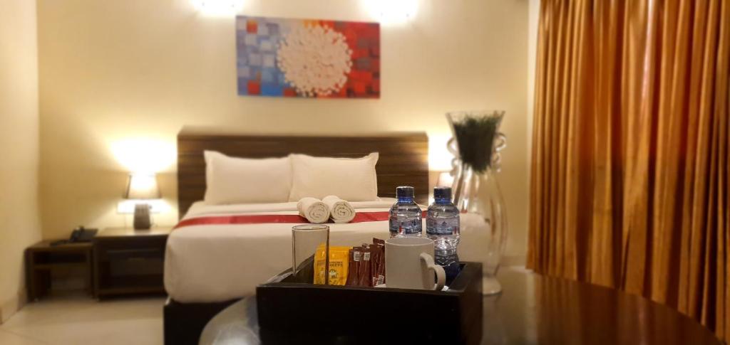 a hotel room with a bed with towels and bottles of water at Hotel Belle Vie in Kinshasa