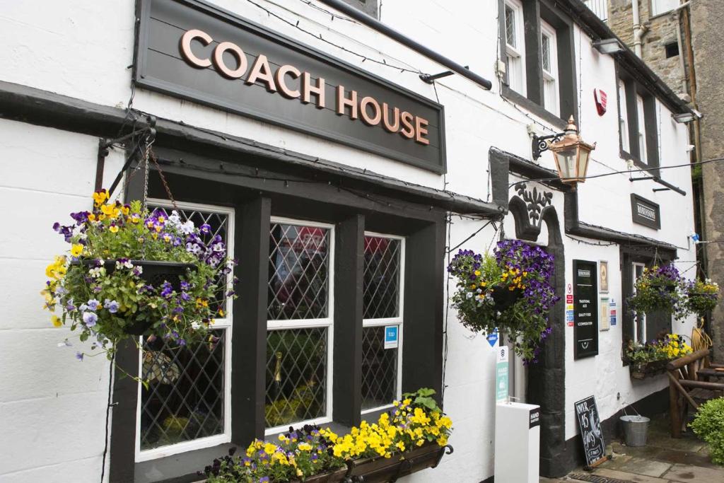 a cork house with flowers in the window at Coach House in High Bentham