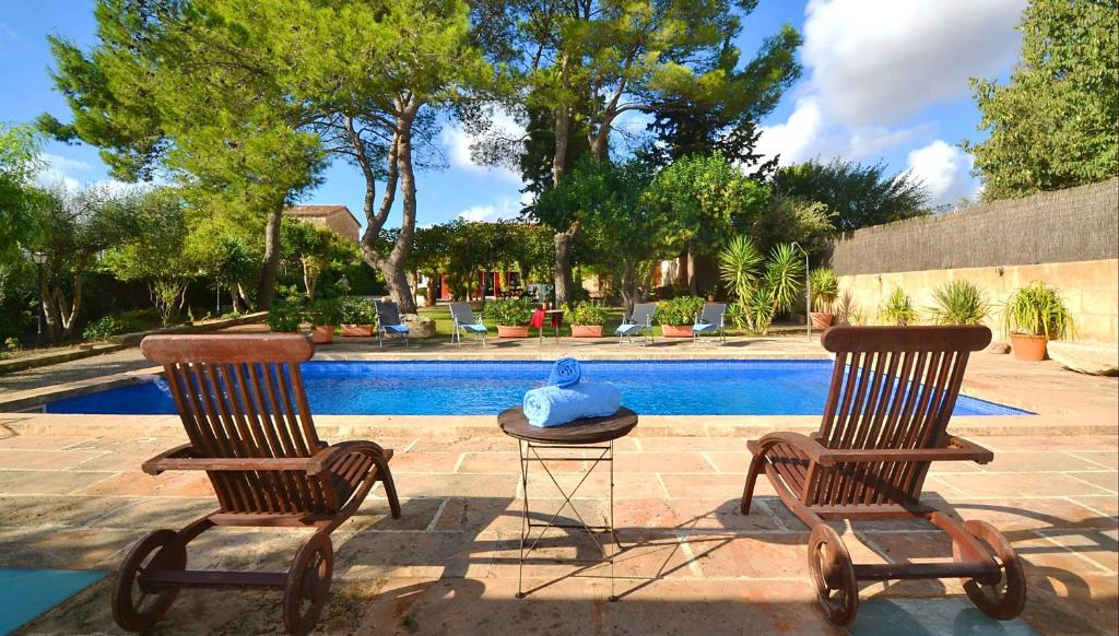 2 sillas y una mesa junto a la piscina en Villa Cas Cosinet by PriorityVillas, en Consell