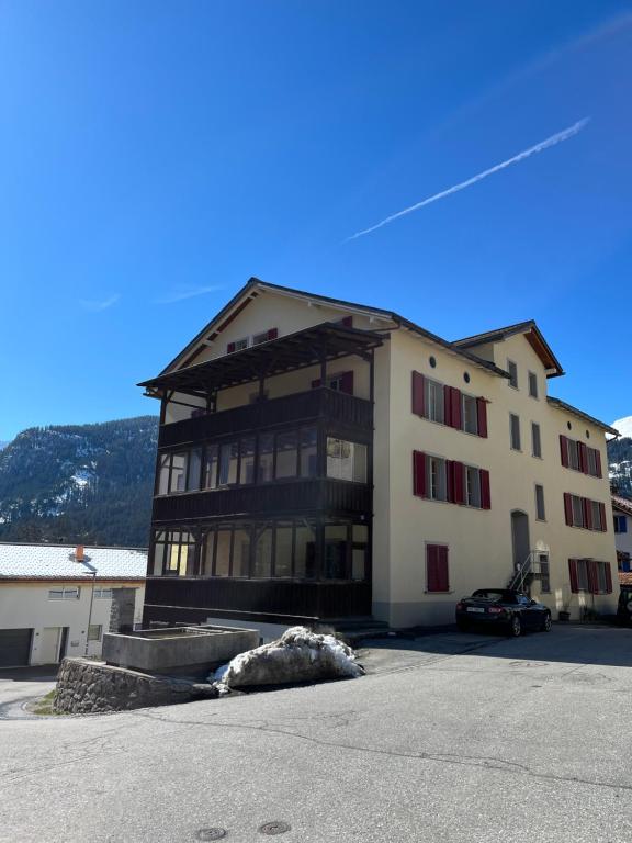 a large building with a car parked in front of it at Charisma Peist Act-Sports Arosa in Peist